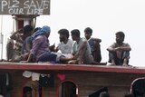 Detained Sri Lankan asylum seekers stand in their wooden boat in Cilegon harbour