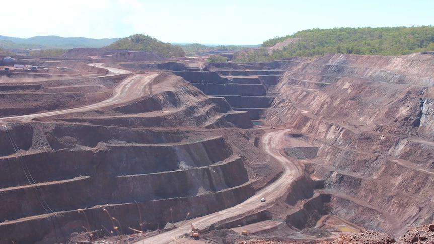 open cut mine pit showing the tiers of mining with a road going down to the bottom