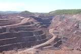open cut mine pit showing the tiers of mining with a road going down to the bottom