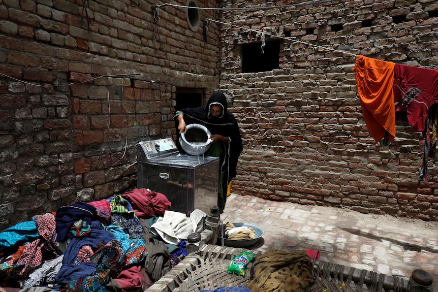 A woman washing clothes at her home.