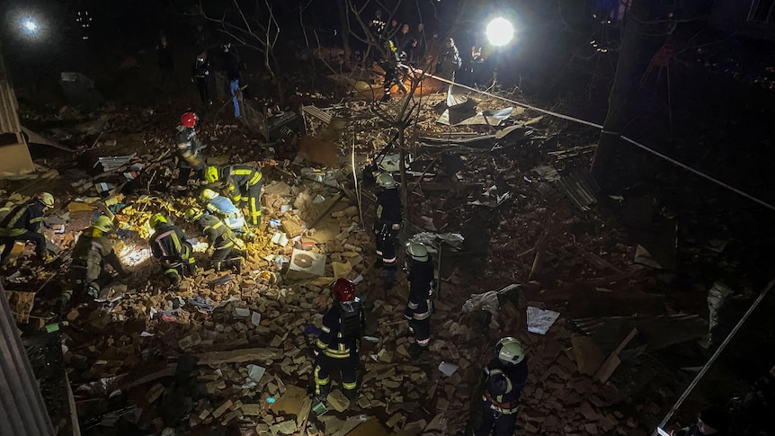 Ukrainian firefighters work at a site of an apartment building severely damaged by a Russian missile strike.