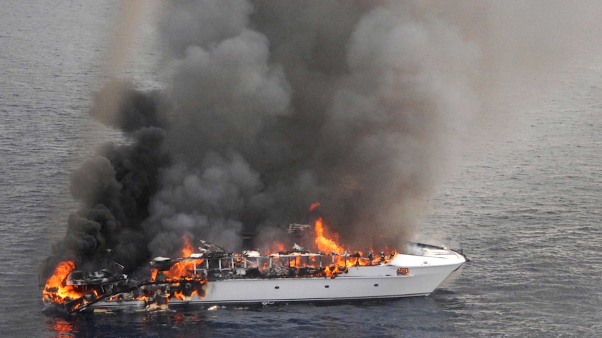 Flames pour from the luxury yacht, the Seafaris, after it caught on fire.