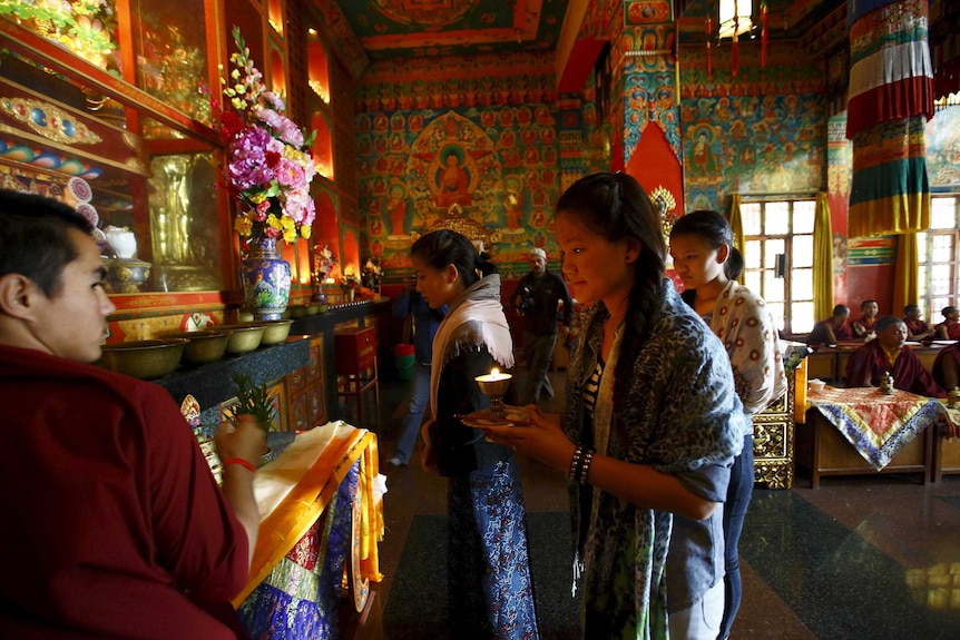 Daughters of Aan Kaji Sherpa light butter lamps in his memory