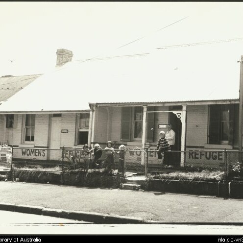 Women standing outside an old terrace house