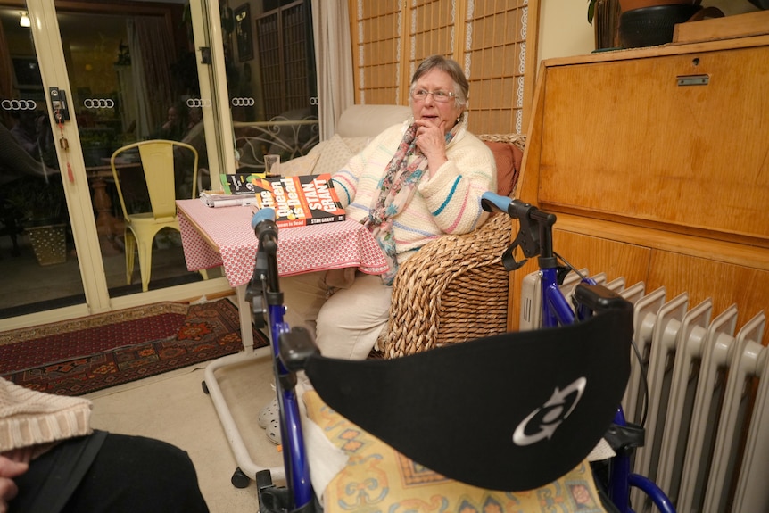 Christine Douglas sits at a table.