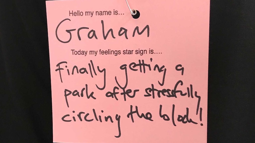 A pink post-it note with a written message about feelings.