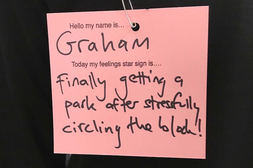 A pink post-it note with a written message about feelings.