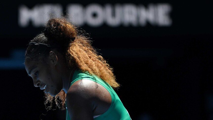 Serena Williams is seen in profile with a pained expression on her face while playing at the Australian Open.