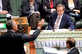 Bill Shorten listens to Joe Hockey as Tony Abbott looks on in Question Time.