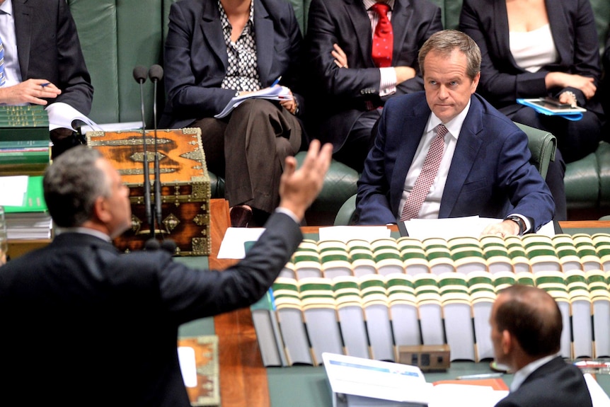 Opposition Leader Bill Shorten listens to Federal Treasurer Joe Hockey as Tony Abbott looks on