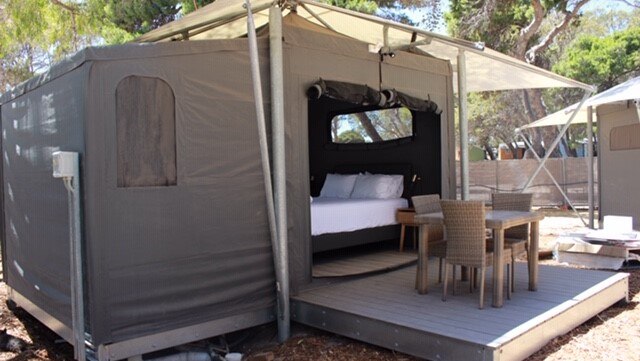 A premium tent with a table and chairs out the front.
