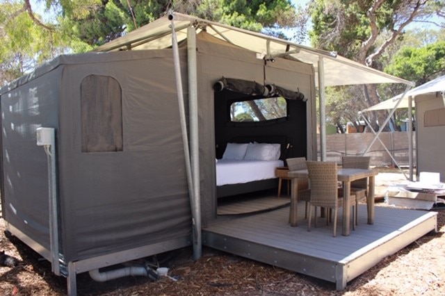 A premium tent with a table and chairs out the front.