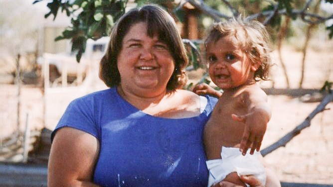 Sarah Sullivan as a baby being held by her mother on the family's station in the 1990s.