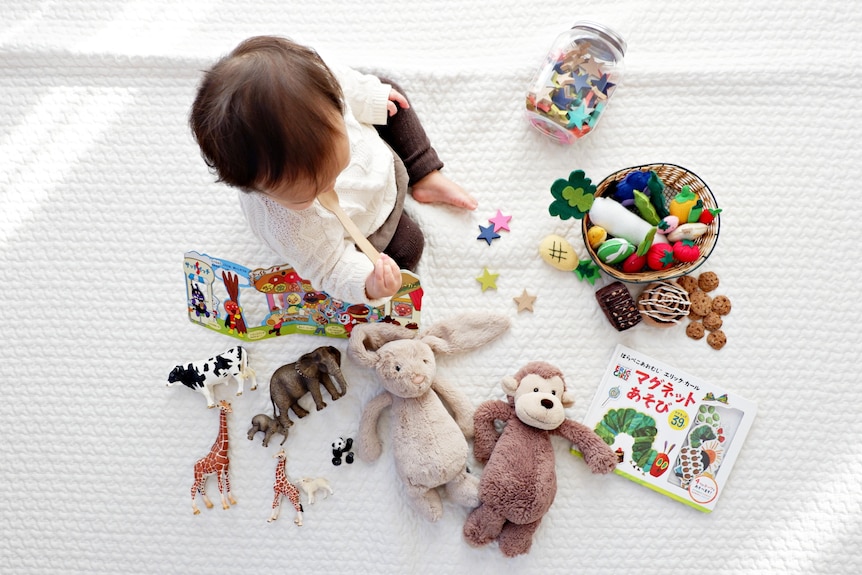 A baby surrounded by toys.