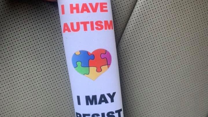 A seatbelt cover with the message: "I have autism. I may resist help".