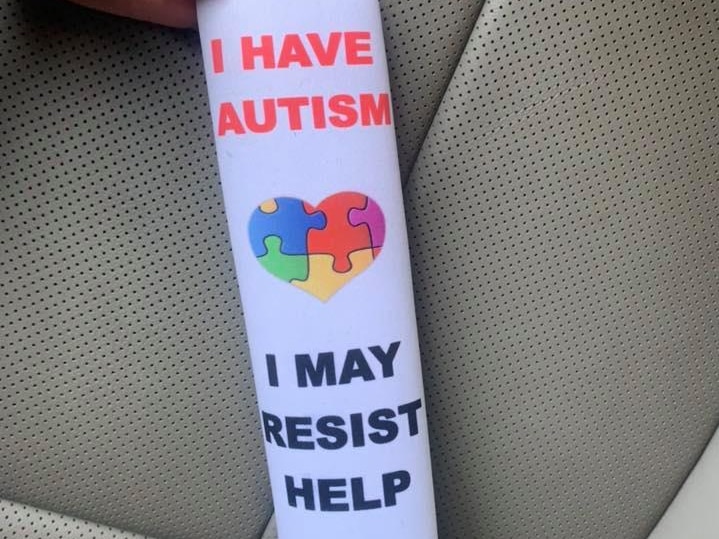 A seatbelt cover with the message: "I have autism. I may resist help".