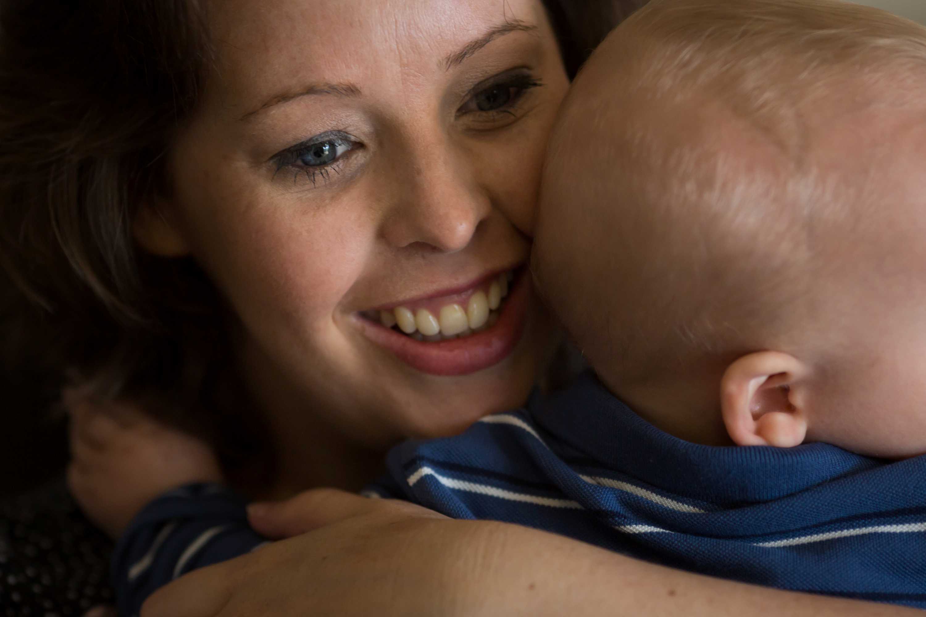 Close up shot of mother Kira Longfield smiling cuddling her baby William.