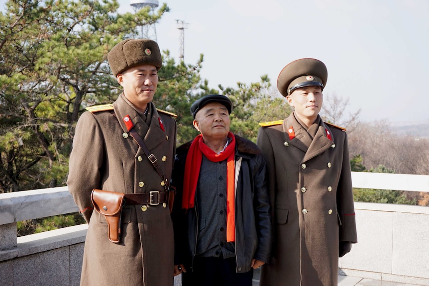 Two soldiers and man in black jacket.