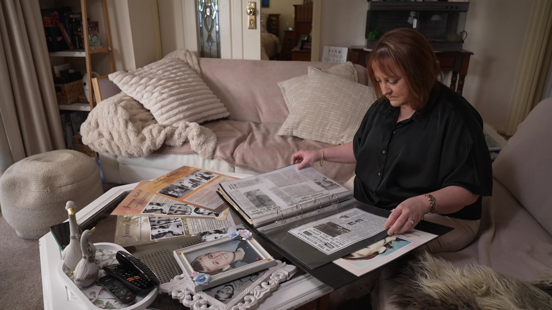 Woman sits down looking at pictures and documents