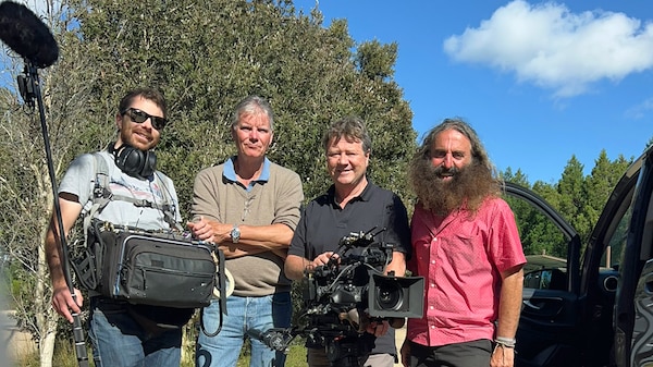 Costa and the film crew standing outside with camera and sound gear.
