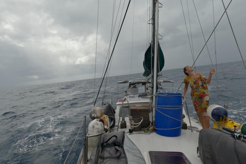 Aiyana checking the mast in rough seas and overcast skies