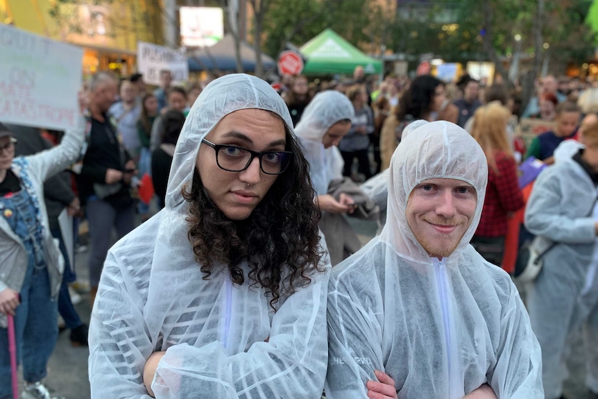 Adani protesters don white jumpsuits in the rain.