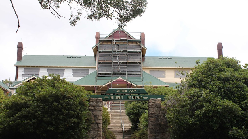 The Mount Buffalo Chalet is covered in scaffolding and surrounded by safety fences.