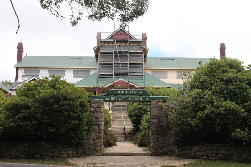 The Mount Buffalo Chalet is covered in scaffolding and surrounded by safety fences.