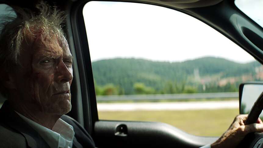 Colour photo of Clint Eastwood driving in 2019 film The Mule.