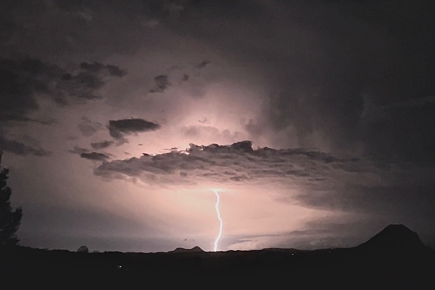 a wide shot of a cloud shooting a lightning strike towards the ground