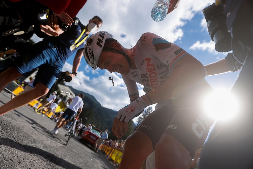 An emotional cyclist bends over to catch his breath after winning a stage at the Tour de France.