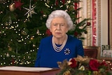 a deepfake image of Queen Elizabeth II sitting infront of a christmas tree