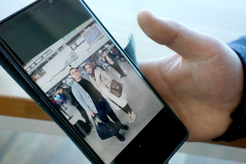 Mr Nizamidin shows a picture of him and his now detained wife.