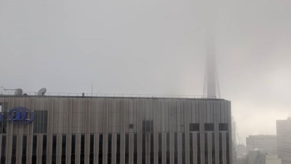 A building disappears into cloud.