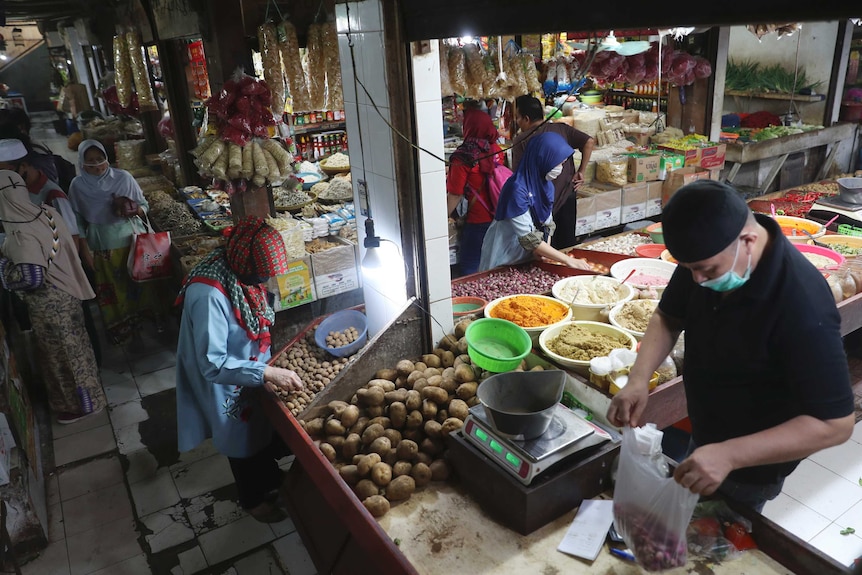 People wear face masks at a market in Jakarta.