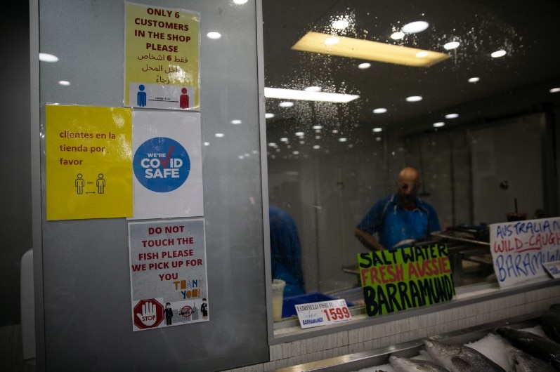 A man cutting up fish in a fish shop.