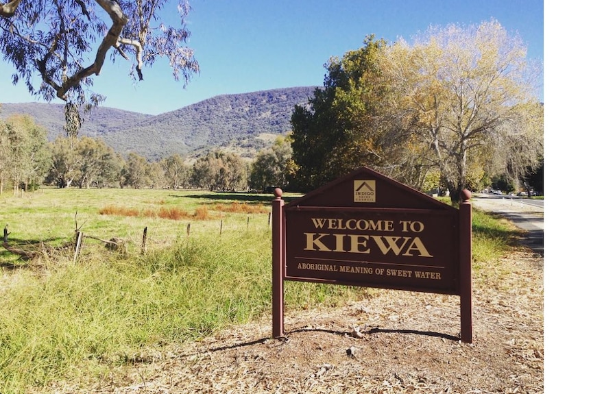 The Kiewa municipality sign with a paddock and mountain behind it. 