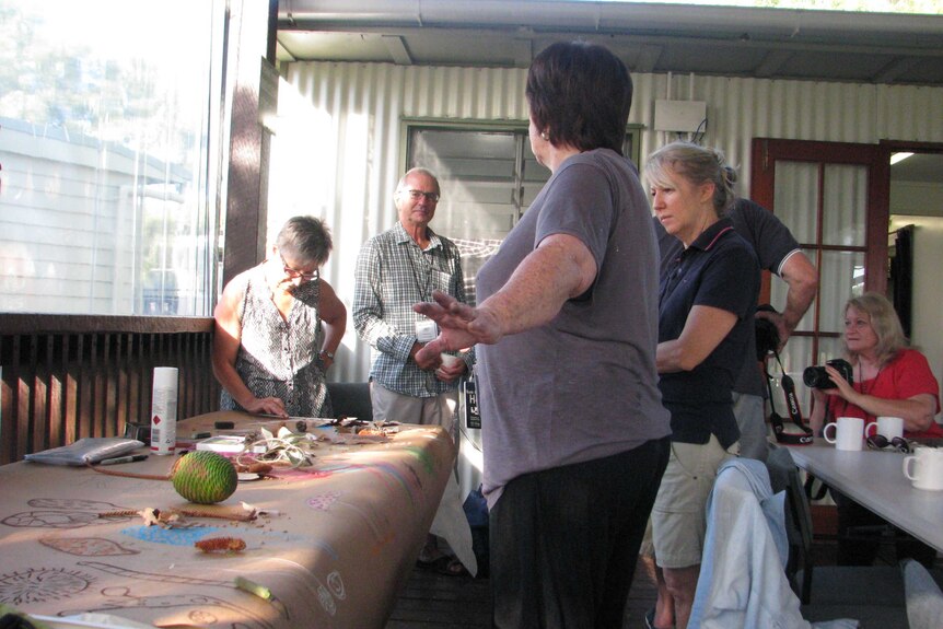 Jo Williams showing a group of people artwork laid out on a table